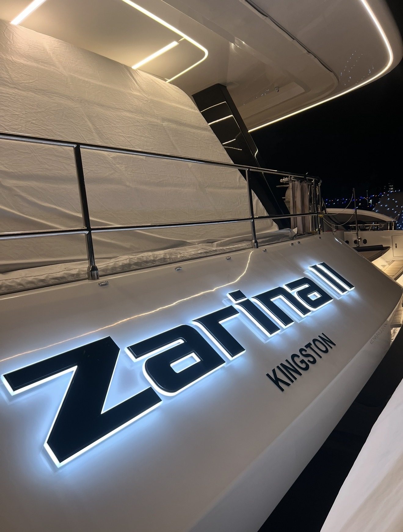 ZARINA II with KINGSTON home port, black-faced letters with white halo lighting on a yacht at night